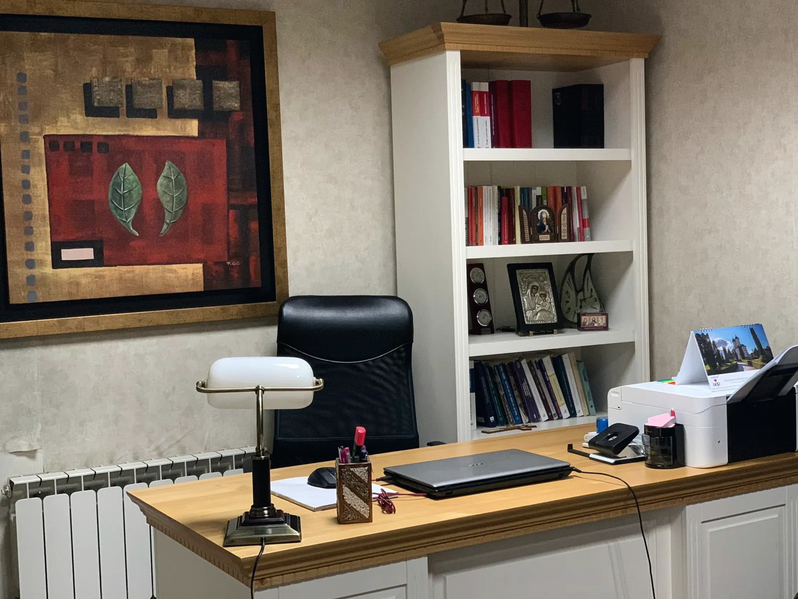 Biroul cabinetului: masa de lucru cu lampa de birou, scaunul și biblioteca